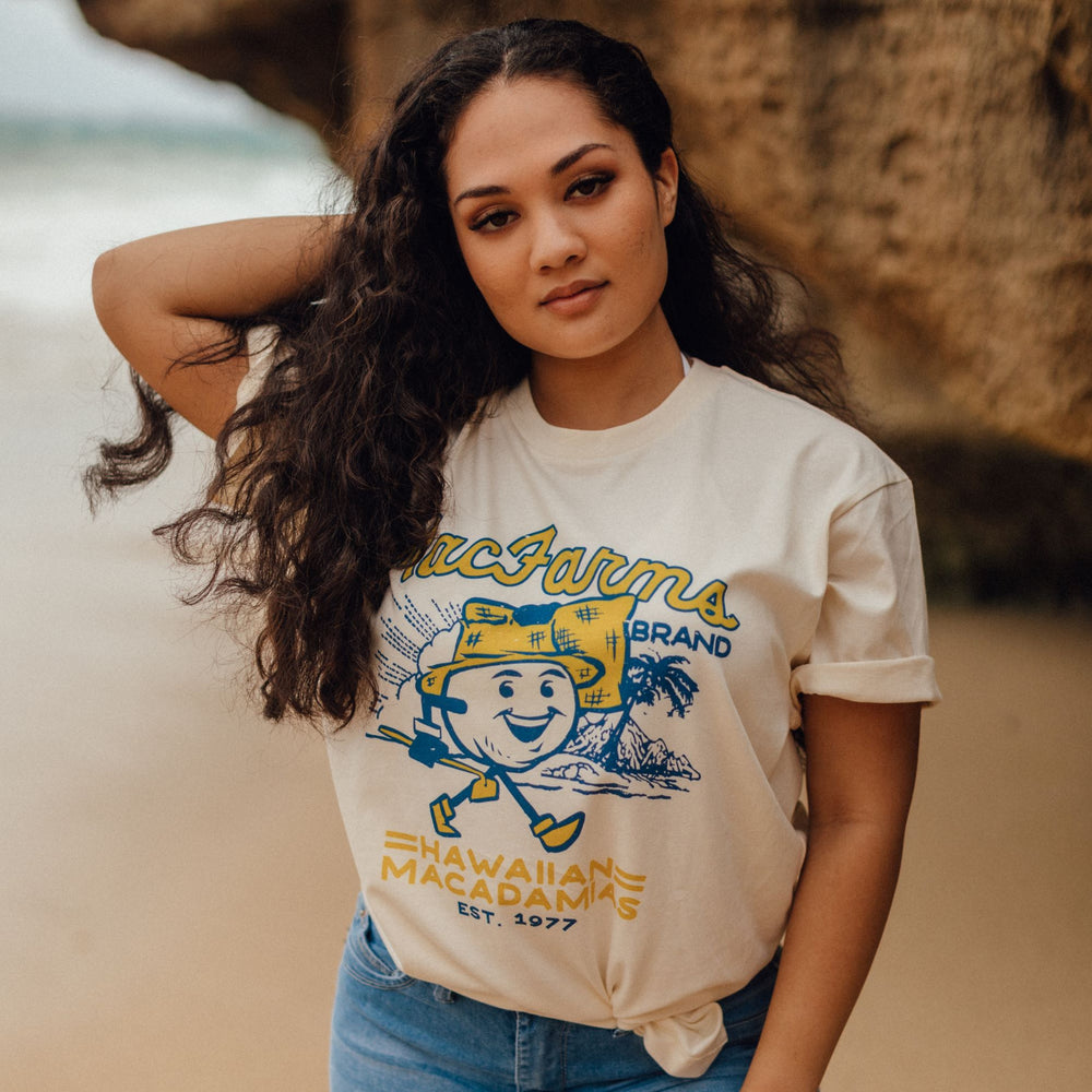woman on beach wearing MacFarms character t-shirt in vintage white